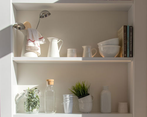 White bookshelf with white ceramic dishes