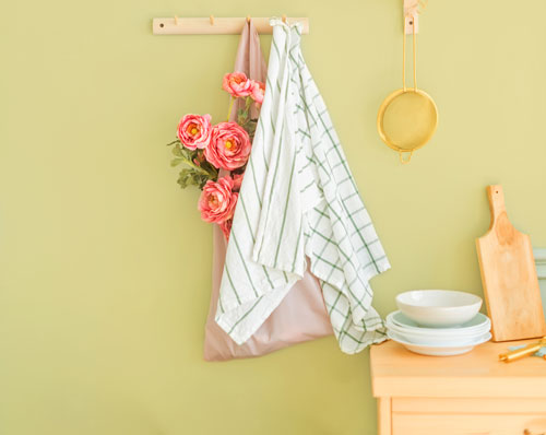 Yellow green kitchen walls wooden pegs and natural wood console