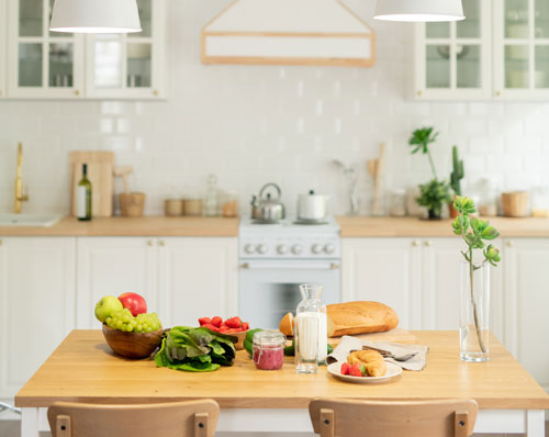 White kitchen with white cabinets and natural wood countertop